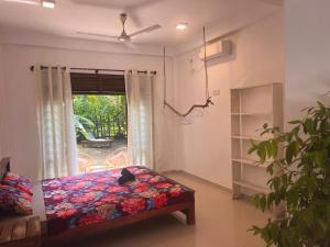 een slaapkamer met een bed voor een raam bij The Drop In Madiha I A/C Suite in Madihe East