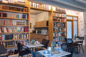 a room with tables and chairs in a library with books at Hotel Casa Luca de Tena in Sopeña