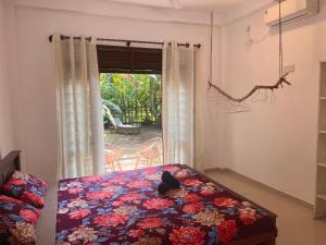 een slaapkamer met een bed voor een raam bij The Drop In Madiha I A/C Suite in Madihe East