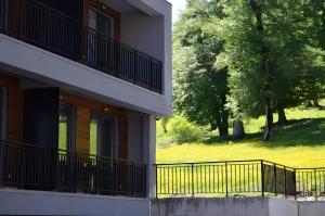 a building with a fence next to a tree at Area Park Bakuriani, Apartment 5 in Bakuriani
