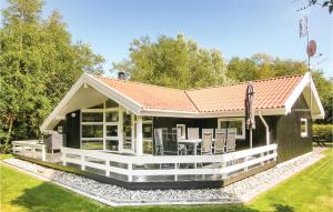 a small black house with a large deck at Holiday Home Humble 34 With Hot Tub in Humble
