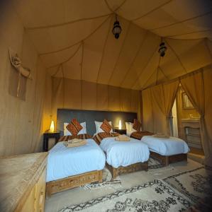 Postel nebo postele na pokoji v ubytování Erg Chebbi Romantic Desert Camp