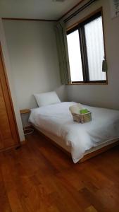 Postel nebo postele na pokoji v ubytování リンゴテラス壺屋