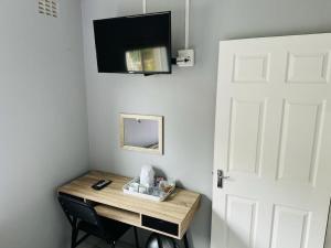 a room with a table with a mirror and a door at Jodwell Guesthouse in East London