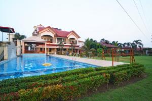a house with a swimming pool in front of a house at Gharana Resort , Singur !! Best Family Resort Near Kolkata with Swimming pool !! in Singur
