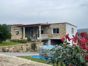 a stone house with a swimming pool in front of it at Casa vanguardista en el campo cerca de Santiago in Pontevedra