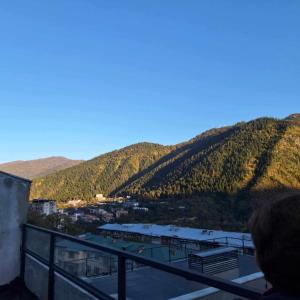 une personne debout sur un balcon donnant sur une montagne dans l'établissement Likani - 407, à Bordjomi 2 autres photos