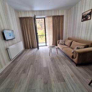 - un salon avec un canapé et du parquet dans l'établissement Likani - 407, à Bordjomi