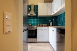 une cuisine avec des placards blancs et du carrelage vert dans l'établissement Campiello Urban Nest by Corfuescapes, à Corfu