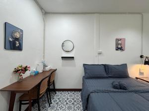a bedroom with a bed and a table and a mirror at Nut Home Hostel in Ban Ko