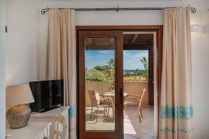 a living room with a sliding glass door leading to a patio at Hotel Mariposas in Villasimius