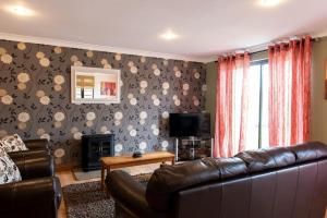 a living room with a leather couch and a television at Harvest 1 Lodge, Yellowtop Country Park in Selby +4 photos