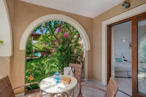a patio with a table and chairs and a garden at Hotel Mariposas in Villasimius