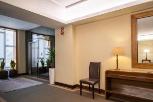 a room with a piano and a chair and a mirror at Hotel Coia de Vigo in Vigo