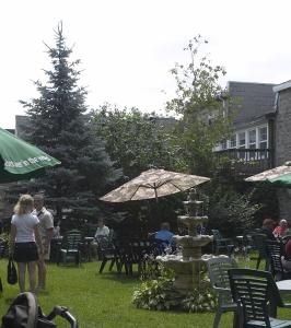 a group of people standing around a fountain in the grass at Baldachin Inn in Merrickville