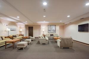 a waiting room with couches and chairs and a television at Hotel Coia de Vigo in Vigo