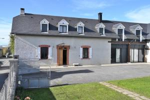 a large white house with a fence in front of it at La maison Poulogne in Capvern