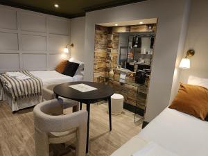 a small room with two beds and a table and chairs at Rooms on The Prom in Cheltenham