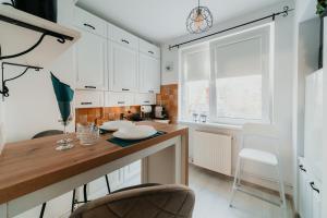 Una cocina con gabinetes blancos y una encimera de madera. en Fanni Apartment, en Odorheiu Secuiesc