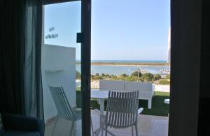 a patio with a table and chairs and a view of the ocean at Garden Playanatural - Adults Only in El Rompido