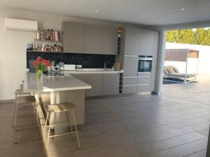 a kitchen with a counter and stools in a room at Villa di lusso con piscina e piccola spiaggia in Callao Salvaje