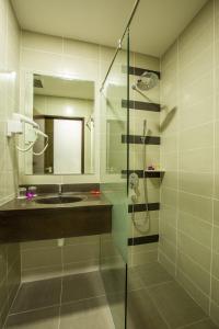 a bathroom with a sink and a glass shower at Humaira Hotel in Tanah Merah