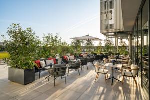 a patio with chairs and tables on a building at INNSiDE by Meliá Madrid Valdebebas in Madrid