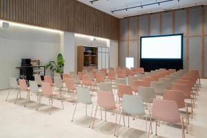 a room with a rows of chairs and a screen at INNSiDE by Meliá Madrid Valdebebas in Madrid +37 photos