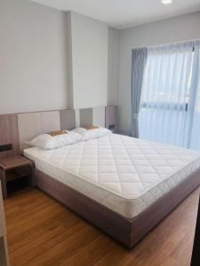 une chambre avec un grand lit blanc avec une fenêtre dans l'établissement The Astra Sky River 2 bedrooms, à Chiang Mai