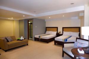 a hotel room with two beds and a couch at Subic Grand Seas Resort in Olongapo