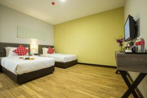 a hotel room with two beds and a flat screen tv at Humaira Hotel in Tanah Merah