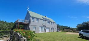una grande casa con una macchina parcheggiata di fronte di The Beech Way Cottage a Cape St Francis