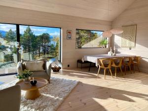 a living room with a table and chairs and a large window at Ny hytte i Malangen in Nordby
