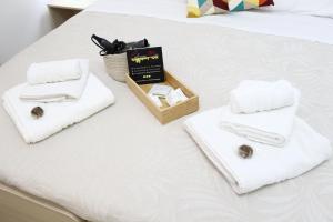 Una cama con toallas y una caja. en Palermo Mia, en Palermo 126 fotos más