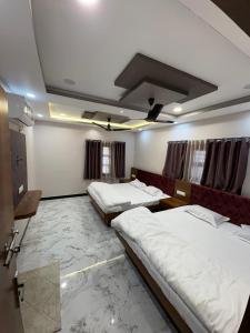 乌贾因shree trilokeshwar guest house的一间设有三张床的房间,其中一张沙发