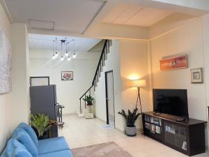 a living room with a blue couch and a tv at Baan Mali one in Hua Hin