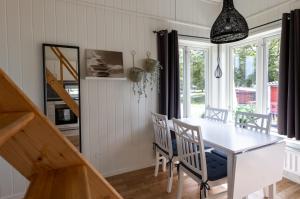 a dining room with a white table and chairs at Evedals Camping Växjö in Växjö