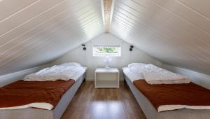 two beds in a small room with a window at Evedals Camping Växjö in Växjö