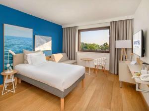a hotel room with a bed and a desk at Novotel Gdańsk Marina in Gdańsk