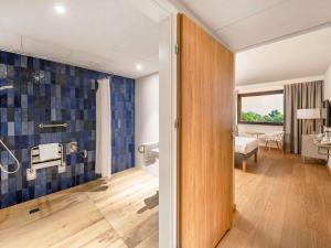 a bathroom with blue tiles on the wall at Novotel Gdańsk Marina in Gdańsk
