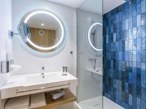 a bathroom with a sink and a mirror at Novotel Gdańsk Marina in Gdańsk