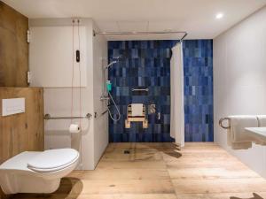 a bathroom with a shower with a toilet and a sink at Novotel Gdańsk Marina in Gdańsk