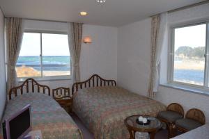 a hotel room with two beds and a view of the beach at Pension Surf Rider in Nishiizu