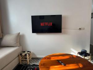 a living room with a table and a tv on the wall at Appartement Fatima in Azrou