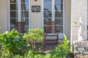 two chairs sitting on the porch of a house at KozyGuru | Thornleigh | Charming Two-Bed Townhouse in Thornleigh +2 photos