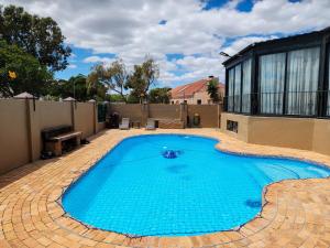 a large swimming pool in a yard with a house at The Seagull in Cape Town