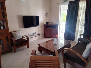 un soggiorno con un divano e un tavolo di Welcome Aboard Villa a Flic-en-Flac
