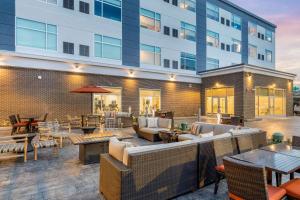 a patio with tables and chairs and a building at Cambria Hotel Milwaukee Downtown in Milwaukee