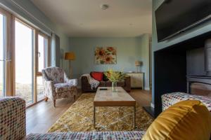a living room with a couch and a table at 1 Ashwood at Thoulstone Park in Westbury