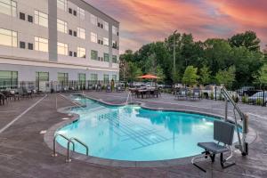 a large swimming pool in front of a building at Cambria Hotel Nashville Airport in Nashville